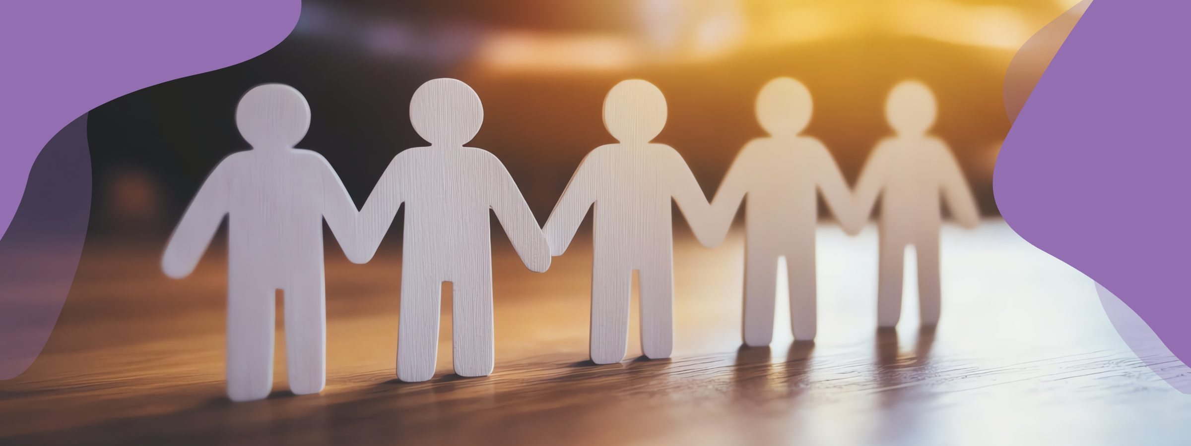 A photo of cut out paper-people in a row holding hands