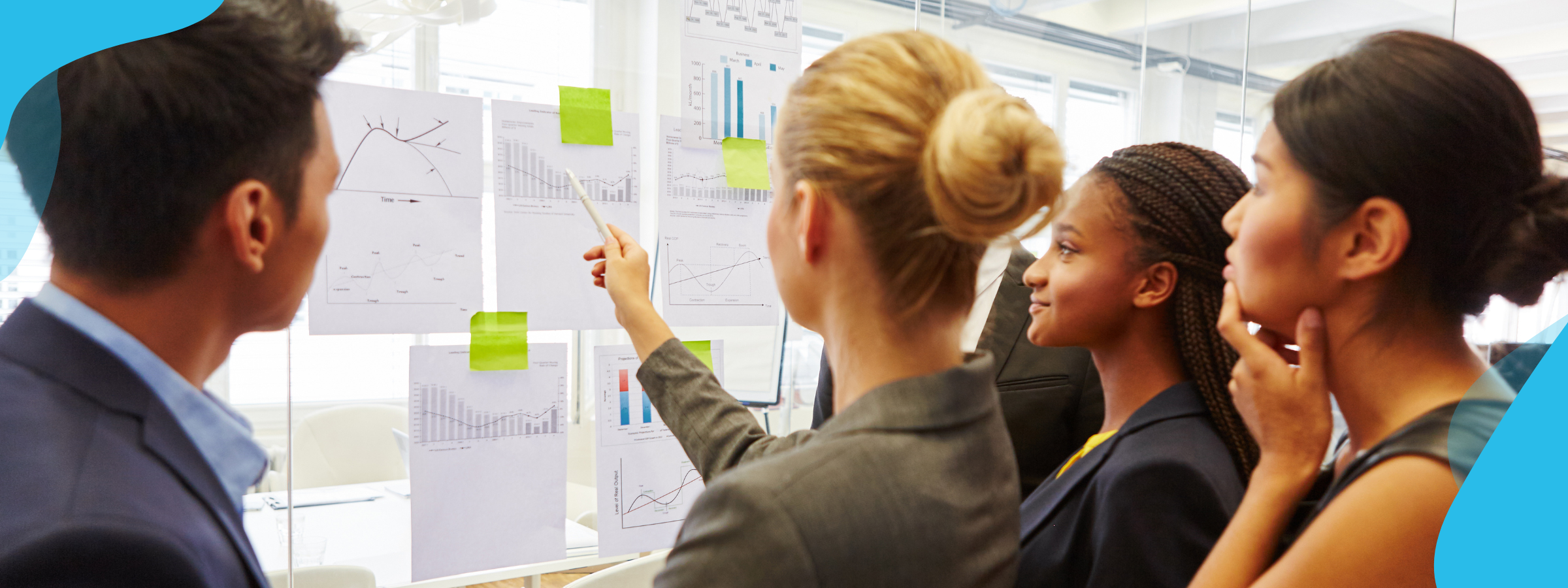 A group of professionals looking at graphs and reports on a board