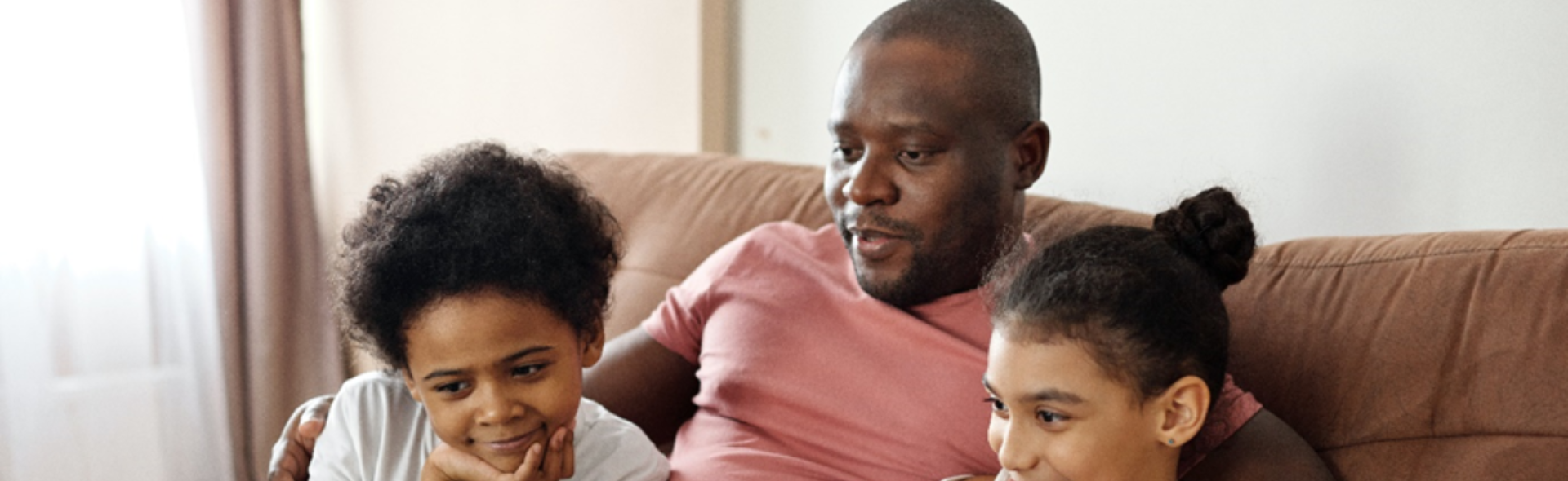 Man and two children gathered around a laptop