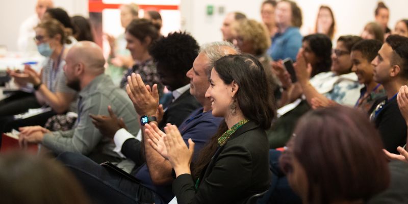 People smiling and clapping in audience