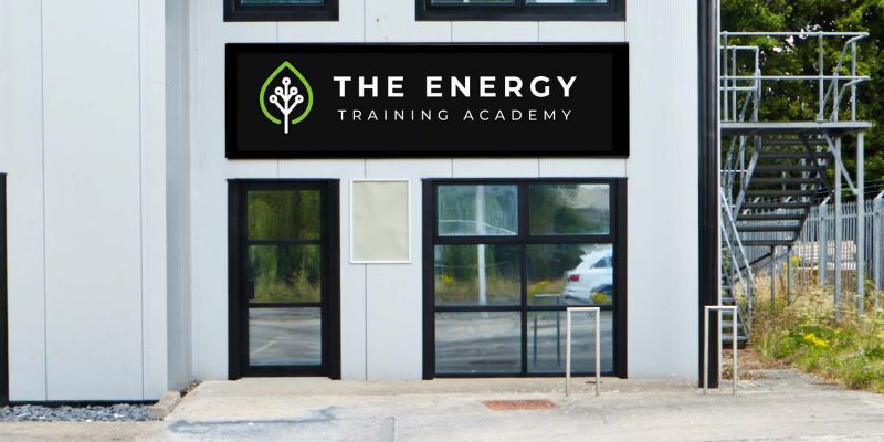 Image of 2 storey white building with black sign and white lettering reading The Energy Training Academy