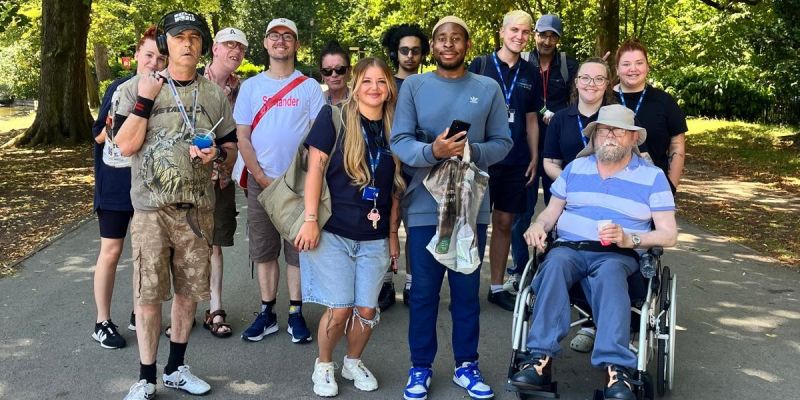 A group of people in the middle of the road in a park posing for a picture