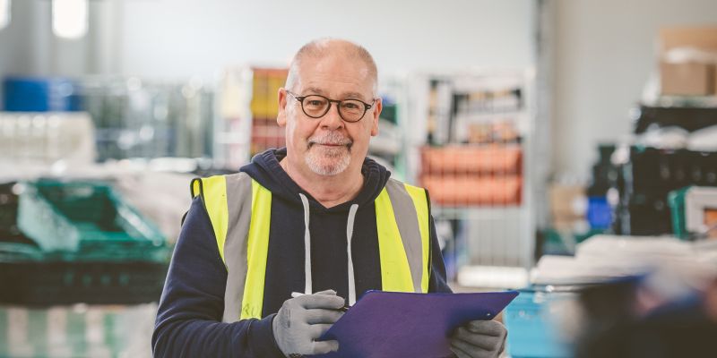 A man holding a clipboard in a warehouse