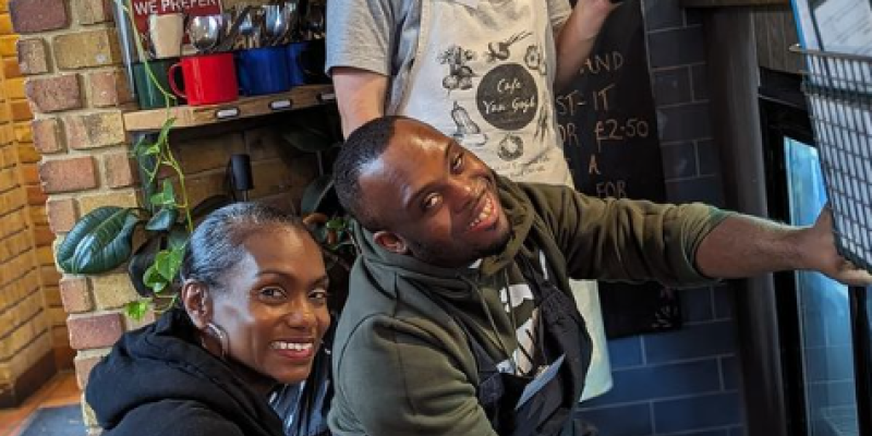 Image shows 3 people behind the desk at a cafe