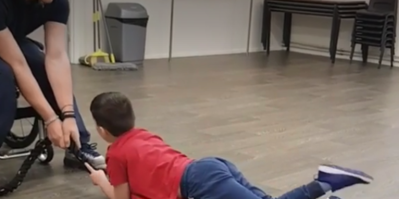 Louis encourages a young client – building core strength.(Taken as a still from video on their website)