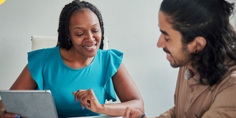 two people sitting at a desk having a conversation