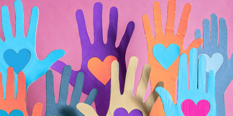 Colourful cut out paper hands with heart shapes in the middle